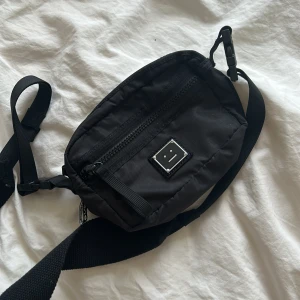 Acne väska  - Säljer denna magväska från Acne. Jättebra skick, endast använd ett fåtal gånger. Köp direkt för 300kr här i appen