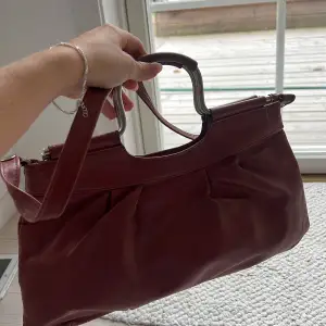 Rosa/röd vintage väska. Mycket rymlig och unik. Inre fack med dragkedja. Stora dragkedjan funkar tyvärr inte och lite sliten. 