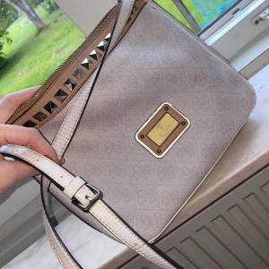 Guess handväska  - Guess handväska som köpt från Zalando nån år sen, använd ett par gånger, finns lite repor längst ner på kanten annars så är den bra i skick.