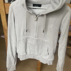 Juicy Couture tröja  - Superfin ljusgrå zip-hoodie från juicy couture! Säljer pga att den tyvärr inte kommer till användning💞 Tröjan är i storlek M men liten i storleken! Inte använd mer än 5 ggr💕💕☺️