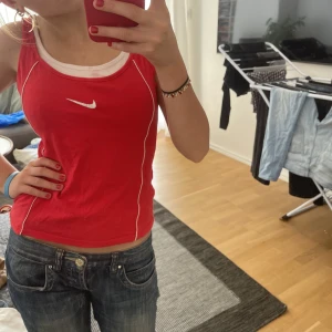 Nike linne - Coolt och unikt nike linne som är från Kate Fashion. Passar mig i då jag är en XS-S. Har dock en liten fläck på de vita längst upp vid halsen, tror man kan bleka bort det med klorin och den blir som ny!