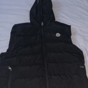 Moncler väst - Storlek XL passar ej mig längre om du tittar på sista bilden så ser du att den är lite i sönder men det går enkelt å fixa hos en skräddare!