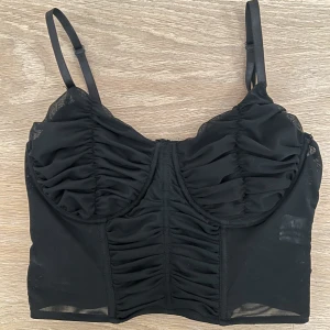 Korsettopp  - Svart korsettopp med bygel samt krok knäppning där bak. I jättefint skick, köpt i Australien på en butik som heter ”Ally” för 350kr. 