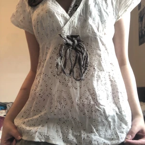 Jättefin vit tröja/blus - Tun och skönt material, jättegulligt mönster och älskar knutten på framsidan, som man själv kan hålla på fixa och justera :) 