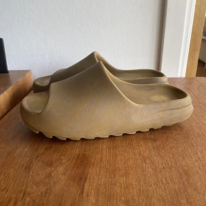 Yeezy Slide Ochre Us 10/Eu44,5 - Använda men i bra skick. Tänk på att det kan vara bra att gå upp en storlek eftersom att dem är ganska små. 1100kr eller Bästa bud.