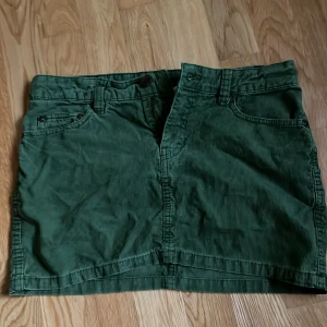 Låg midjad kjol - Jätte fin lågmidjad jeans kjol den är lite lätt ribbad men det syns knappast. Den är oliv grön köpt från h&m. Den är i väldigt bra skick. Säljer pga att den är för liten. Använd ett får tall gånger💕