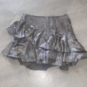 Kjol, ZARA  - Silver kjol från ZARA. Storlek M, mindre i storleken. Ser ut som ny. Har shorts inuti.