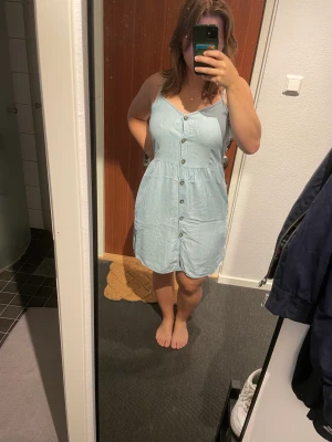 Klänning - Klänning med knappar framtill. Har sytt på insidan av översta knappen då den gick sönder, inget som syns utifrån. Storlek M