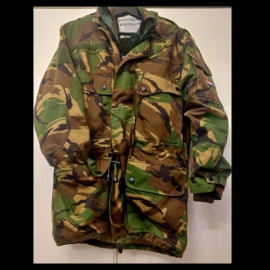 Holländska arméns jacka 3 lager - En arméjacka från 2001 och gjord i Nederländska/Holland i oanvänt skick. Jackan har 3 lager (värmelager, kamoflaugelager och regnlager) som gör att det går att vika in materialet beroende på behov och väder.