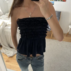 Mörkblå Bandeutopp med volanger - Jättefin mörkblå topp med små ”volanger” framtill!