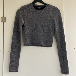 Glittrig topp - Glittrig långärmad och croppad topp från Monki. Aldrig använd 🖤✨