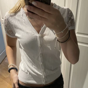 Vit topp - En vit topp med spetts armar. Det står inte någon lapp vart den är ifrån eller storlek. Men skulle säga att storleken är xs 