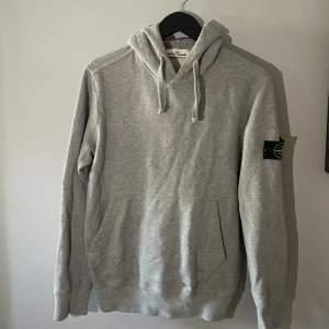 Grå Stone Island hoodie, bra kvalitet och knappt använd.  Nypris ca 3200 kr 