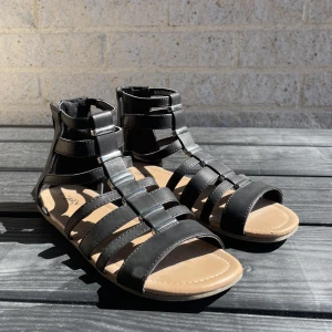 Svarta sandaler - Sandaler från märket Zoey. Svart fuskskinn och silverdetaljer, stängs med dragkedja i bak. 