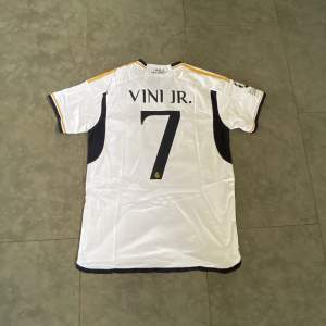 Snygg Real Madrid tröja från säsongen 23/24. Vinicius Junior på ryggen. Helt ny med Champions League badge. Storlek M