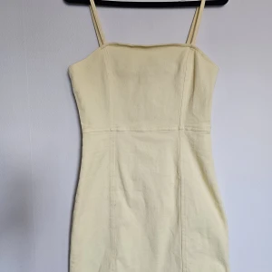 Gul minidress - Gul minidress i denim med spaghetti-straps och dragkedja bak. Aldrig använd (bara testad), i mycket gott skick! Storlek 38. Tvättas självklart innan utskick/överlämning! 