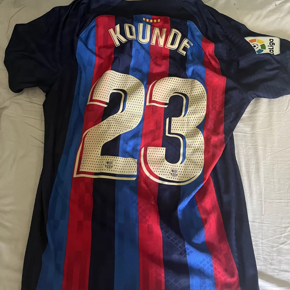 Autentisk spelarversion av Barcelonas hemmatröja 22/23   Jules Kounde på ryggen.   Använd ett par gånger ej tvättad, i köpt nyligen för 1800kr på Nike.   Storlek XL men sitter något mindre pga spelarversionen. . T-shirts.