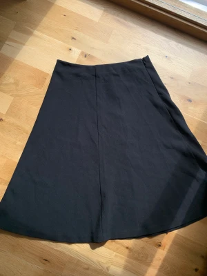 Midi Kjol - Svart midi kjol från åhléns med prislapp kvar. Strlk 38, funkar också bra för en S. Högmidjad och midi längd. 