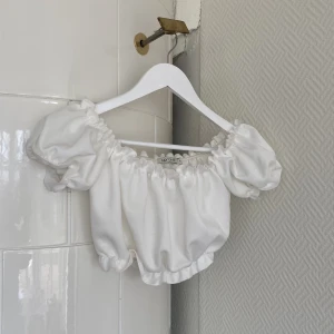 Topp - Vit off-shoulder topp från Nelly i storlek S, använd fåtal gånger. Går även att ha uppe på axlarna lika bra som nerhasat 🤍