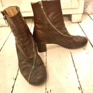 Acne stövletter - Bruna skinnboots från Acne, tidig kollektion. Dragkedja som går att öppna hela vägen riktigt balla! Du kommer garanterat vara ensam om dessa. Kan behöva en putsning men i bra vintage-skick. 