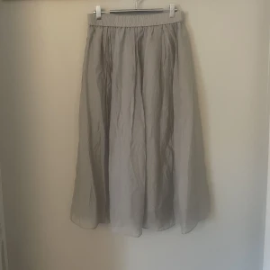 Ljusgrå långkjol  - Väldigt fin och härlig kjol i en ljusgrå färg. Köpt men aldrig använd då den tyvärr inte passade