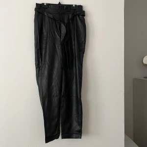 Högmidjade skinnbyxor - Snygga högmidjade skinnbyxor med knyte i midjan. Storlek 36