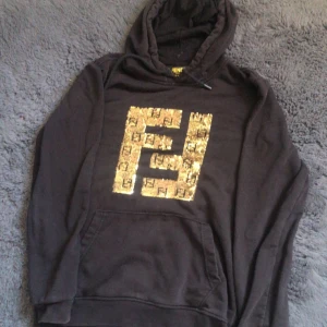 Fendi hoodie  - En äkta Fendi hoodie som är helt svart och är guldig i mitten, De är storlek S för killar men både tjejer o killar kan ha på sig den men den är Annpasad för killar,den är ganska ny, har haft den på få gånger bara, priset kan alltid diskuteras