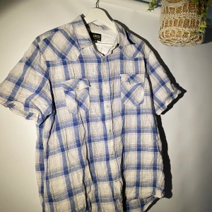 Kortärmad Skjorta från RDWD - Hej, säljer en somrig kortärmad skjorta från RDWD. Den är i väldigt bra skick. Storlek XL men passar även L om man gillar oversized. Blå/vit randigt mönster. Perfekt inför sommaren. Hör av dig vid frågor.