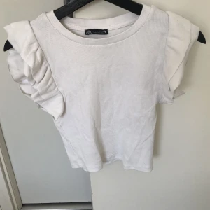Zara topp ” t-shirt med volangärmar ” - Jag säljer den här toppen från zara. Jag köpte den av en på Plick och det är storlek m. Har inte använt den så mkt Max 2-3 gånger Hör av er innan ni tänker köpa