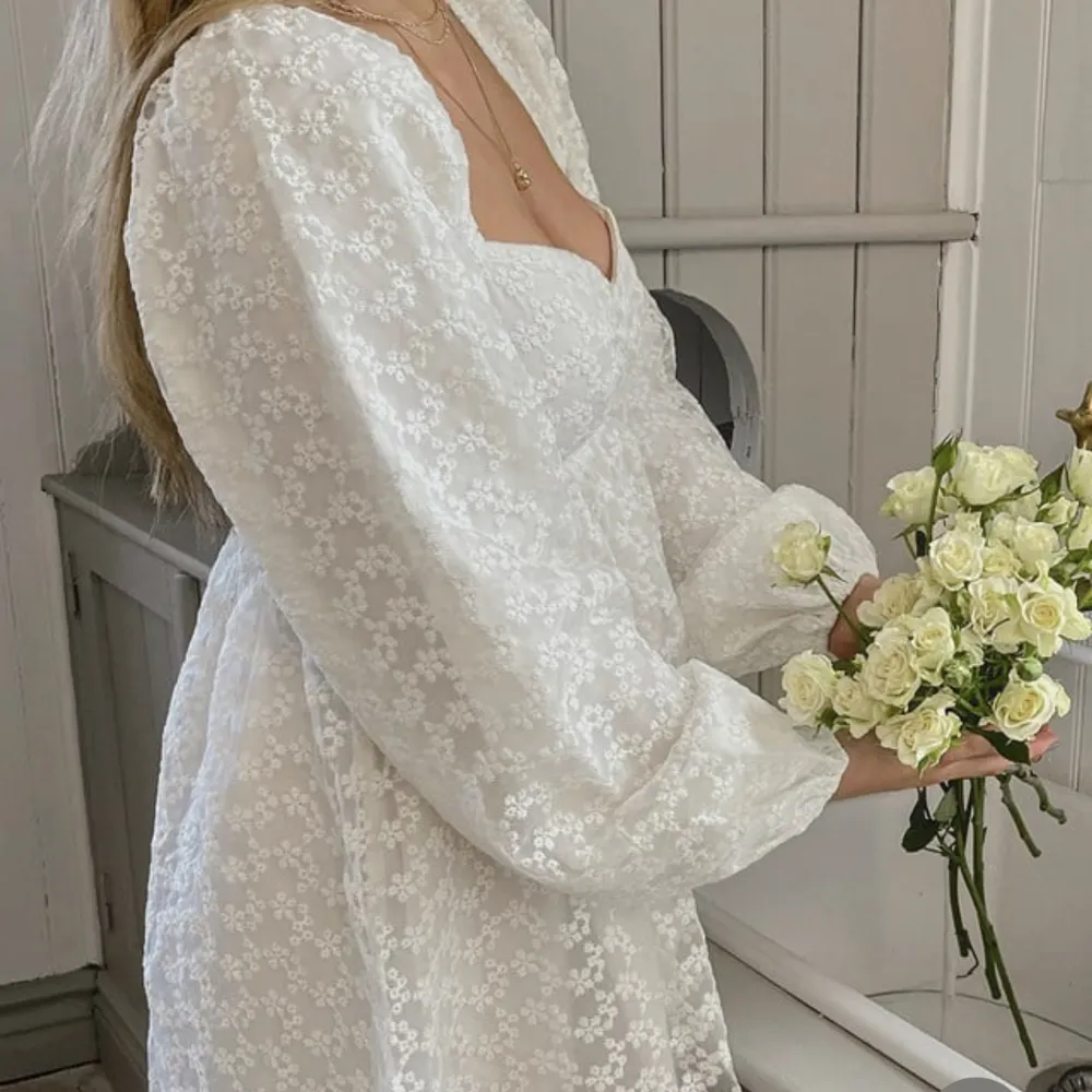 Supersöt vit puffig klänning från NA-KD med blommönster. Använd vid två tillfällen, jättebra skick . Klänningar.
