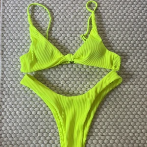 Bikini - En neongul bikini i strl s med silvriga detaljer. Skulle säga att toppen är lite liten i storlek, frakt tillkommer 