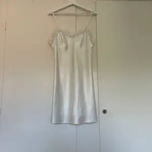 Superfin vit slipdress i satin som också kan vara ett nattlinne. Den är tyvärr för stor för mig. Obs den har två små hål 