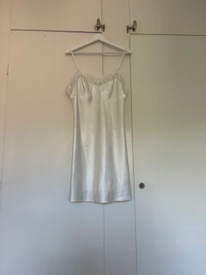 Satin klänning - Superfin vit slipdress i satin som också kan vara ett nattlinne. Den är tyvärr för stor för mig. Obs den har två små hål 