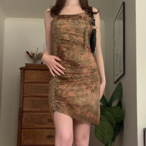 Mönstrad klänning - Grön/orange midiklänning i lite rufflat spets-material och med coola axelband, från märket Lulu.H! Står ingen storlek men är som en XS/S 💓