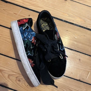 Puma skor  - Svarta puma skor med blommor på sidorna, använda ca 2-3 gånger 