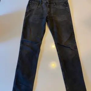 Ett par svarta replay jeans. Jeansen har ett hål på varje ben nere vid hälen. De går absolut att använda men de är lite slitna.