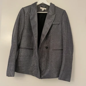 Glittrig Kavaj 36 - Glittrig Kavaj från HM. Normal passform, varken oversize eller smal. Använd 1 gång så i nyskick.