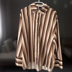 Skjorta och byxor set  - Jätte fint randigt set i jordfärger, detta är ett helt nytt sett som inte kommit till användning. Både över och under delen är i storlek M men passar för er i storlek L. 