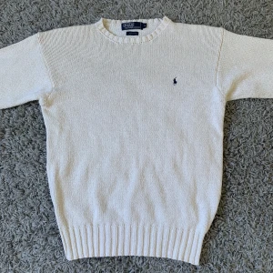 Stickad Ralph Lauren tröja - En fin krämvit stickad ralph lauren tröja som passar perfekt till hösten och vintern. Den är inte använd och är i 10/10 skick. Nypris: 2000kr