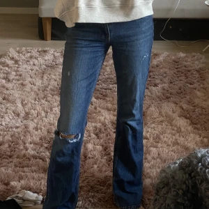 Lågmidjade jeans  - Lågmidjade jeans från Gina, hålen har jag gjort själv men tycker bara de är en fin detalj! Annars är dom i nyskick och använda bara några få gånger. BUDA🫶🏻💞