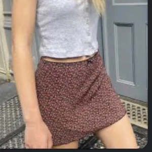 Svart röd mönstrad kort Brandy kjol  - Aldrig använd. Lånade bilder 1 och 2