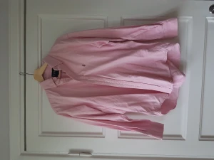 Rosa finskjorta från Ralph, strl L?  - Fin rosa skjorta från Ralph i strlk L? (10). Jag har använt denna som oversize skjorta, så den passar även S-L beroende på hur man vill att den ska sitta.