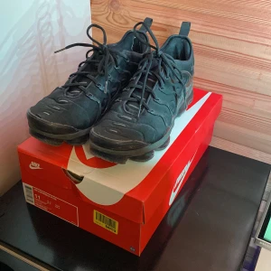 Nike Vapormax Plus  - Nike Vapormax plus i storlek 45. Skorna är i använt skick vilket syns på bilderna, alla flaws syns i bilderna (hål framtill och vid hälen). Utöver det är dem i använt skick men går absolut att använda! Säljs billigt 