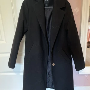 Svart kappa - Svart kappa som funkar både i lite varmare och kallare väder. Mycket fint skick! 