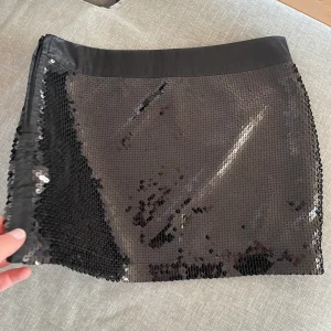 Glittrig mini kjol - Säljer denna glittriga minikjol. Innerkjolen är uppsprättad på ena sidan så man kan dra ner den till lågmidjat💕