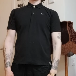 Svart Nike piké - En svart Nike piké i lite sportigt material