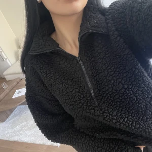 Svart lurvig tröja  - Svart lurvig tröja med dragkedja vid halsen. 