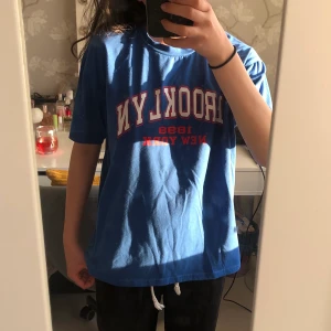 T-shirt - Säljer en blå T-shirt med ett coolt tryck på. Från SHEIN i strl. S. Använda under hösten 21 och har de senaste åren legat i garderoben. Sparsamt använd! Köparen står för frakten😇