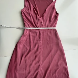 Rosa satinklönning med öppen rygg - Rosa satinklönning från Bubbleroom Stl S