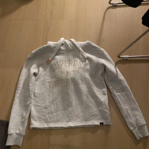 Superdry Hoodie - Sänkt pris!! Hoodie från Superdry i storlek Xs, men passar även S. Något croopad i modellen, på en Xs syns det inte så mycket, men blir mer croopad på en S.   Tyvärr knappt använd och därav säljer jag. Den är i nyskick! 
